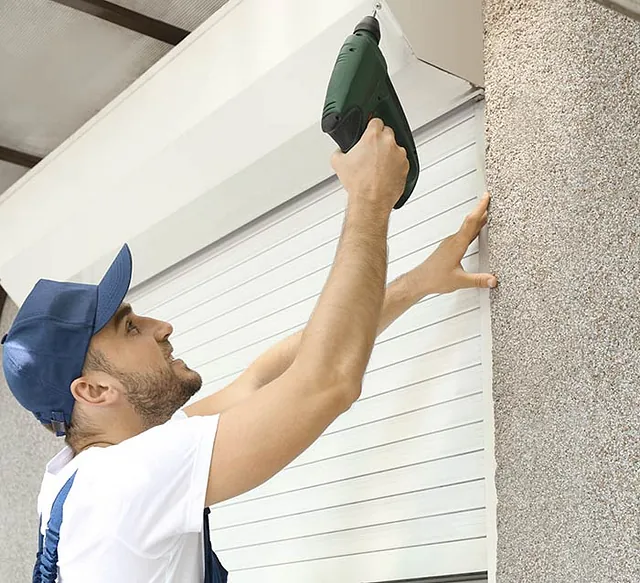 Hombre instalando persiana para local comercial